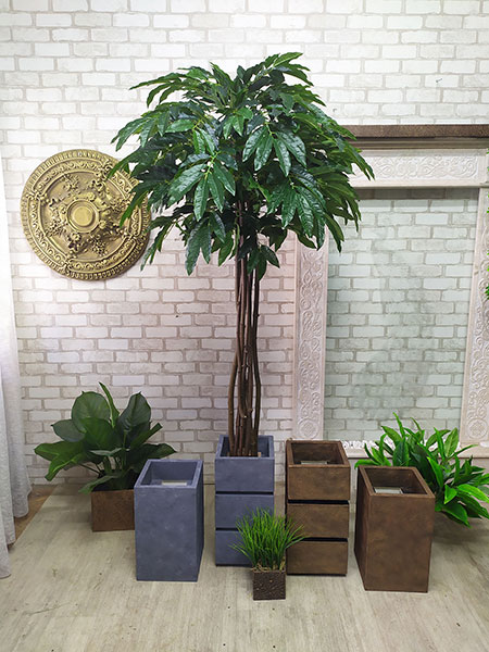 Decorative tree with artificial large ficus leaves for the interior of a furniture store