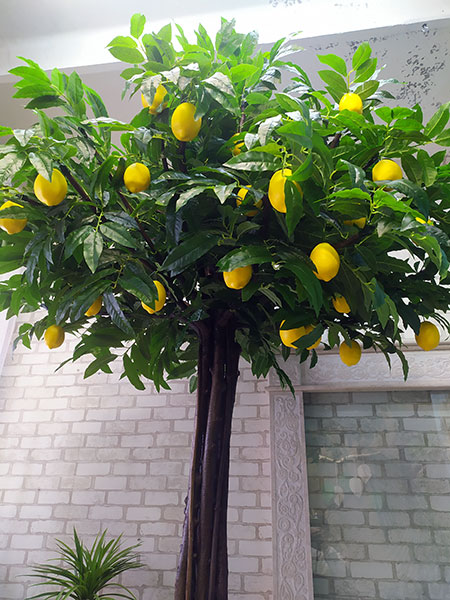 Artificial big tree with lemons. Fruit tree for restaurant interior